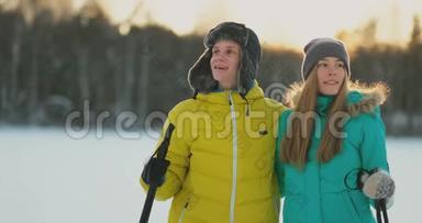 在日落时分的冬季森林里，一男一女一滑雪，看着大自然的美景和慢镜头